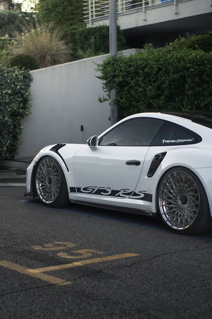 White Porsche GT3 RS on forged wheels, side profile, parked street-side