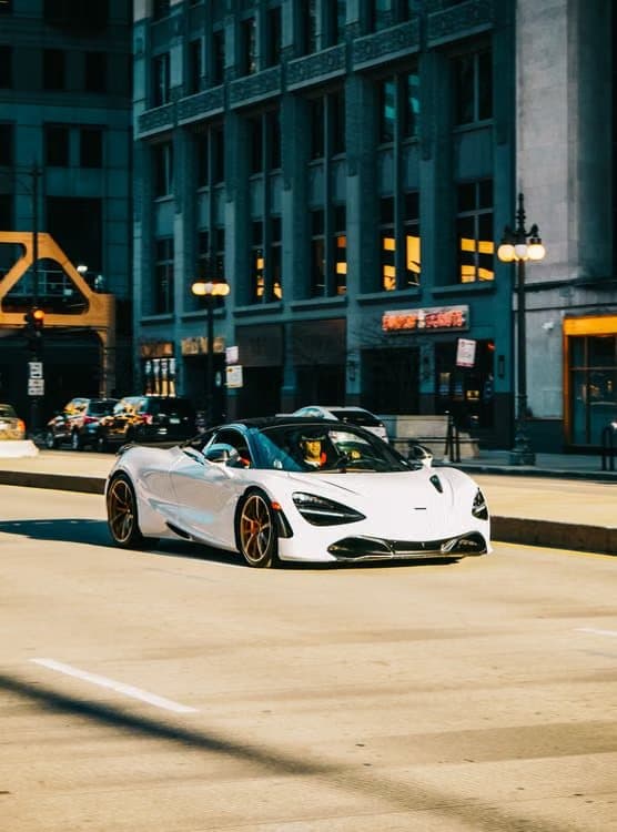 White McLaren 720S Spider driving down a city street